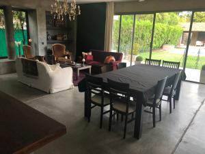 uma sala de estar com uma mesa preta e cadeiras em Loft Chacras de Coria em Chacras de Coria