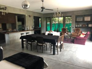 uma sala de jantar e sala de estar com uma mesa preta e cadeiras em Loft Chacras de Coria em Chacras de Coria