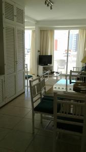 a living room with a table and chairs and a television at Peninsula in Punta del Este