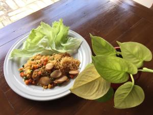 a plate of food with lettuce and vegetables on a table at Baan Ing Ping in Chiang Mai