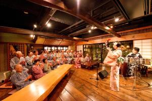 Eine Frau singt vor einer Menschenmenge in der Unterkunft Hotel Tamanoyu in Matsumoto