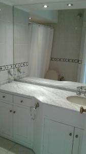 a white bathroom with a sink and a mirror at Peninsula in Punta del Este
