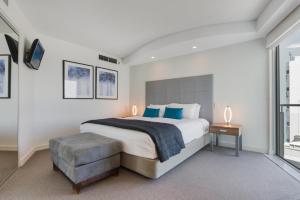 a bedroom with a bed, a desk and a window at Mantra Sirocco in Mooloolaba
