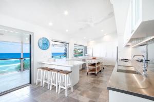 una cucina bianca con vista sull'oceano di Ocean Panorama With Private Pool! a Noosa Heads Altre 18 foto