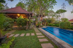 ウブドにあるPuri Cili Villa Ubudのプールと家のあるヴィラ
