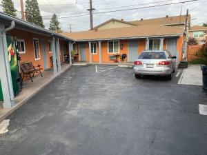 a car parked in a parking lot in front of a house at SunLight Motel Long Beach in Long Beach