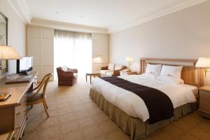 木更津市にあるオークラアカデミアパークホテルの大きなベッドとデスクが備わるホテルルームです。