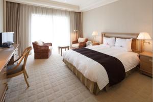 木更津市にあるオークラアカデミアパークホテルの大型ベッドとテレビが備わるホテルルームです。