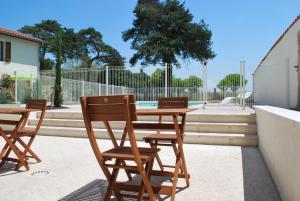 a wooden table and chairs sitting at a table at Chambres d'hôtes La Leva in Villette-dʼAnthon