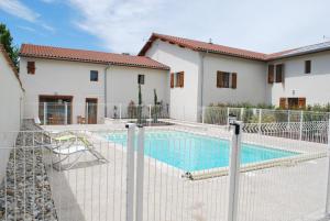 une maison avec une piscine derrière une clôture dans l'établissement Chambres d'hôtes La Leva, à Villette-dʼAnthon