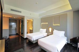 Un pat sau paturi într-o cameră la Swiss-Belhotel Cirebon