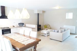 a kitchen and living room with a table and chairs at Chambres d'hôtes La Leva in Villette-dʼAnthon