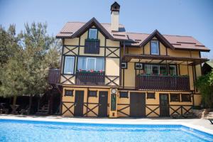 a house with a pool in front of it at Baden Baden Butik Hotel in Arkhipo-Osipovka