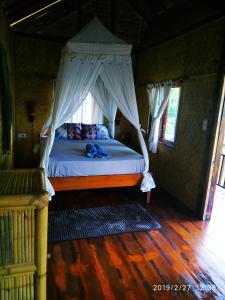 En eller flere senge i et værelse på Kampung Meno Bungalows