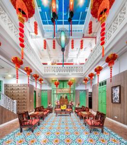 un grand hall avec des lanternes rouges, des tables et des chaises dans l'établissement Ama Hostel Bangkok, à Bangkok