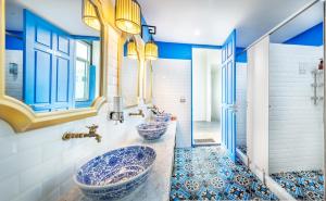 two sinks in a bathroom with blue and white tiles at Ama Hostel Bangkok in Bangkok