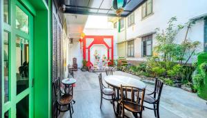 a room with a table and chairs on a patio at Ama Hostel Bangkok in Bangkok