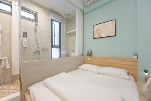 a bedroom with a white bed and a shower at OX Suites in Kaohsiung