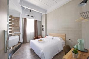 Habitación de hotel con cama blanca y mesa en OX Suites, en Kaohsiung