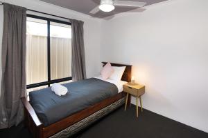 a bedroom with a bed with a large window at Tootys Place in Margaret River Town