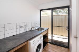 a kitchen with a sink and a washing machine at Tootys Place in Margaret River Town