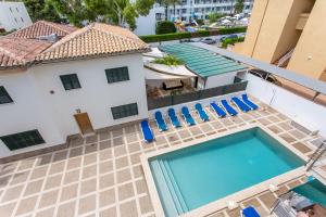 an overhead view of a swimming pool on a building with blue chairs at Tramuntana & Beach in Pollença