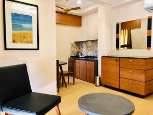 a living room with a table and a kitchen at Merlot Suites in Porvorim