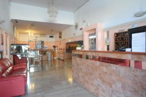 a bar in a restaurant with red chairs and a counter at Albergo Gino in Ancona