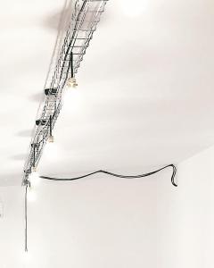 een ladder hangend aan een wit plafond met een bord bij Casa Anna in Ilbono