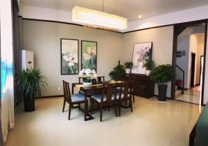 a dining room with a table and chairs and plants at Sanya Haitangwan Shang Gong Yuan She Wellness Resort Villa in Sanya +20 photos