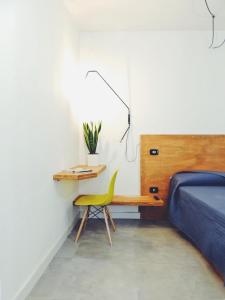 een slaapkamer met een bed en een bureau met een gele stoel bij Casa Anna in Ilbono