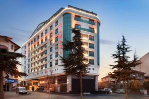 ein hohes Gebäude mit einem Baum davor in der Unterkunft Ramada by Wyndham Isparta in Isparta