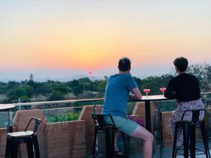 two people sitting at a table watching the sunset at Bagan Sense Hotel in Bagan
