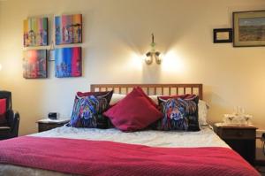 1 dormitorio con 1 cama con sábanas y almohadas rosas en Ashcroft Farmhouse en East Calder