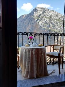 una mesa con un jarrón de flores en el balcón en La Stella, en Civita