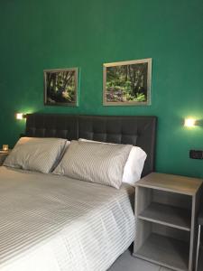 a bedroom with a bed with a green wall at La Dimora in Catania