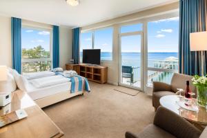 a bedroom with a bed and a view of the ocean at Hotel Bellevue in Timmendorfer Strand