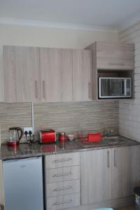 a kitchen with wooden cabinets and a counter top at Apple Orchard Cottage in Harrismith +4 photos