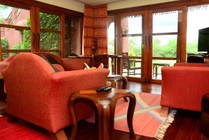 a living room with two chairs and a table at Amboseli Serena Safari Lodge in Amboseli
