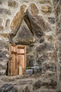 una pared de piedra con un armario de madera y una planta en un estante en Vecchio Forno Casa Vacanze, en Montefalco