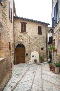 un callejón con un edificio con una puerta de madera en Vecchio Forno Casa Vacanze, en Montefalco