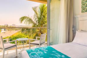 a bedroom with a bed and a balcony with a view at Blue Beach Galle in Galle