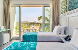 a hotel room with a bed and a large window at Blue Beach Galle in Galle
