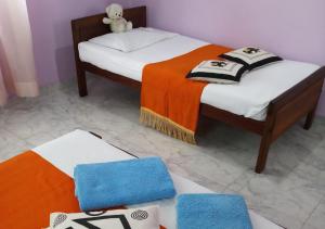 two beds in a room with a teddy bear sitting on top at VILLA CHAND KALUTARA in Kalutara +71 photos
