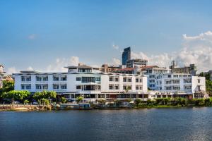 duży biały budynek obok zbiornika wodnego w obiekcie Huong Giang Hotel Resort & Spa w mieście Hue