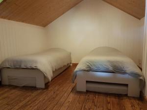 Habitación pequeña con 2 camas y suelo de madera. en Woodstone, en Herbeumont