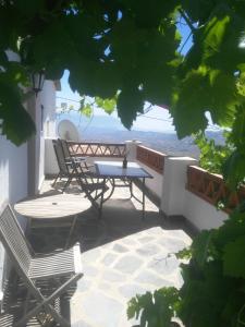 een patio met een tafel en stoelen op een balkon bij Casa Rural El Paraje de Berchules in Bérchules