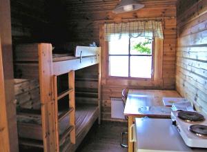 cocina con litera en una cabaña de madera en Camping Toivolansaari, en Ikaalinen