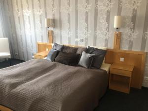 um quarto com uma cama grande e duas mesas de cabeceira em deckert`s Hotel an der Klosterpforte em Lutherstadt Eisleben