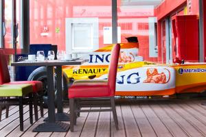 una mesa con un coche de carreras en la pared de un restaurante en Enzo Hotels Reims Tinqueux by Kyriad Direct, en Reims